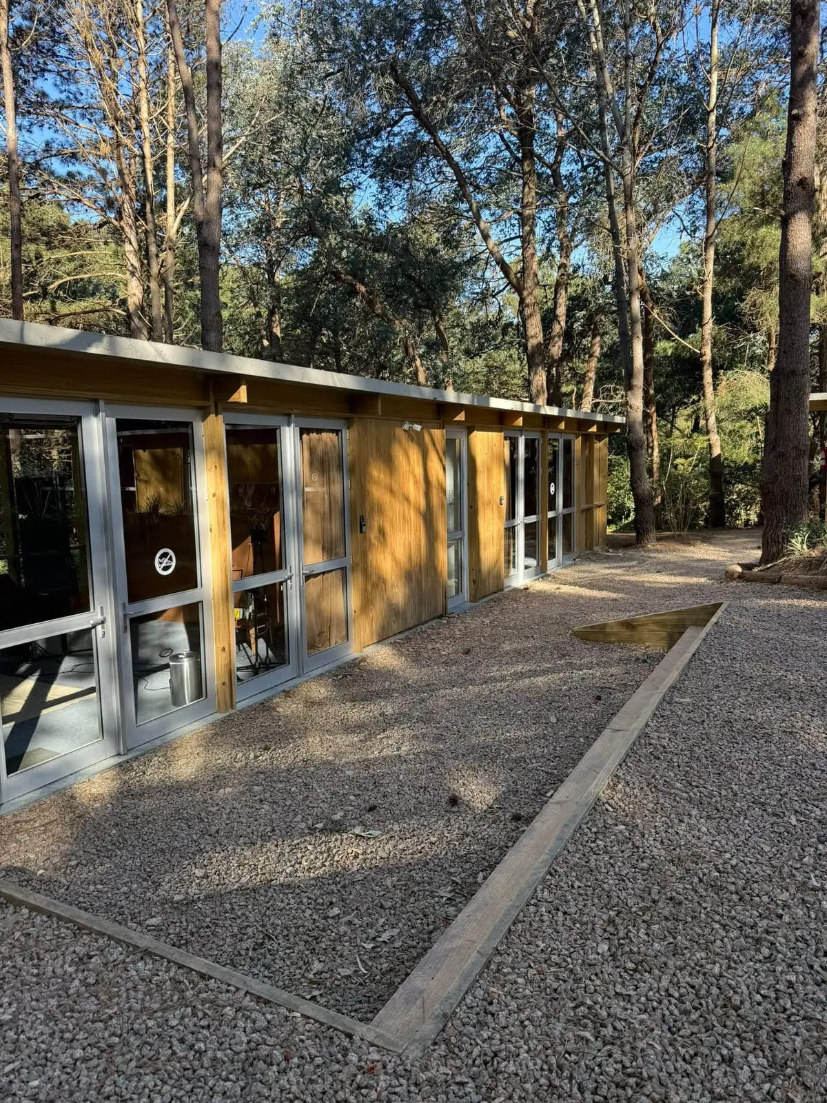Frente de un módulo, con sus ventanales hacia el patio · Portal Bosque, La Barra, Uruguay